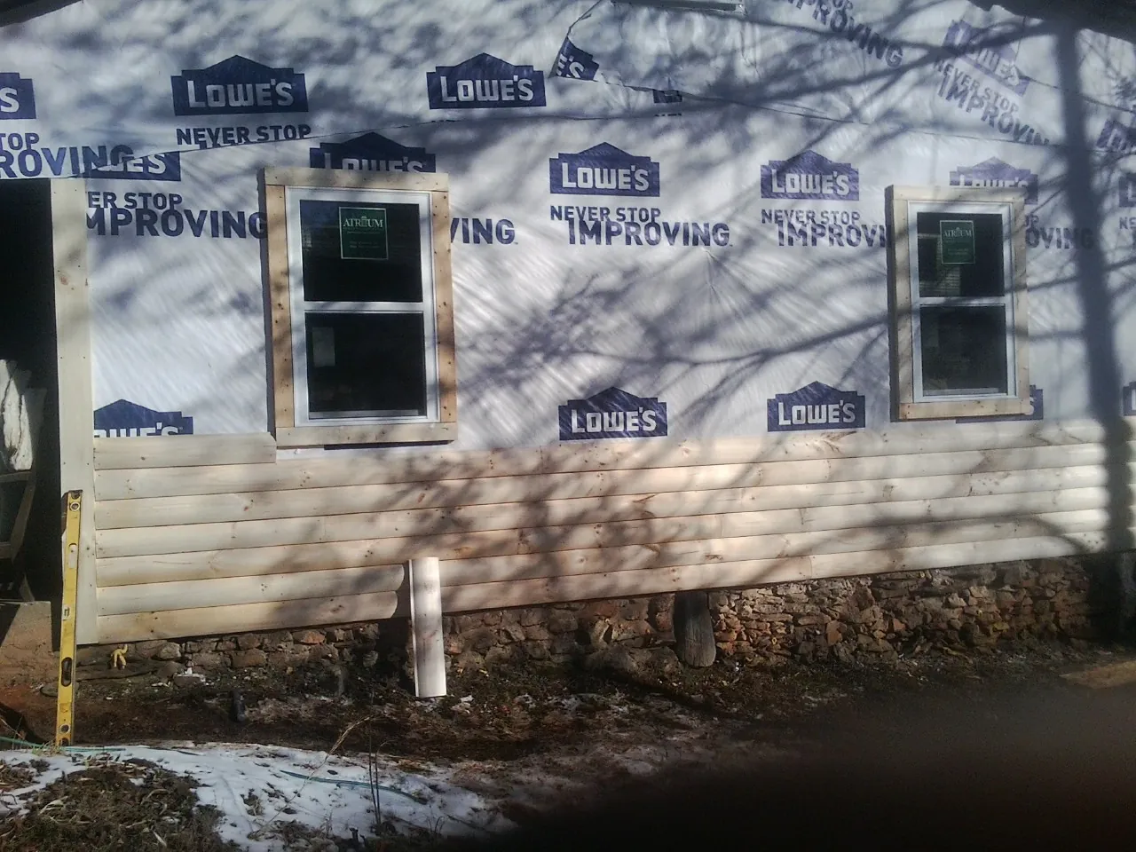 House wrap and new log siding going up on an exterior wall in Irwin