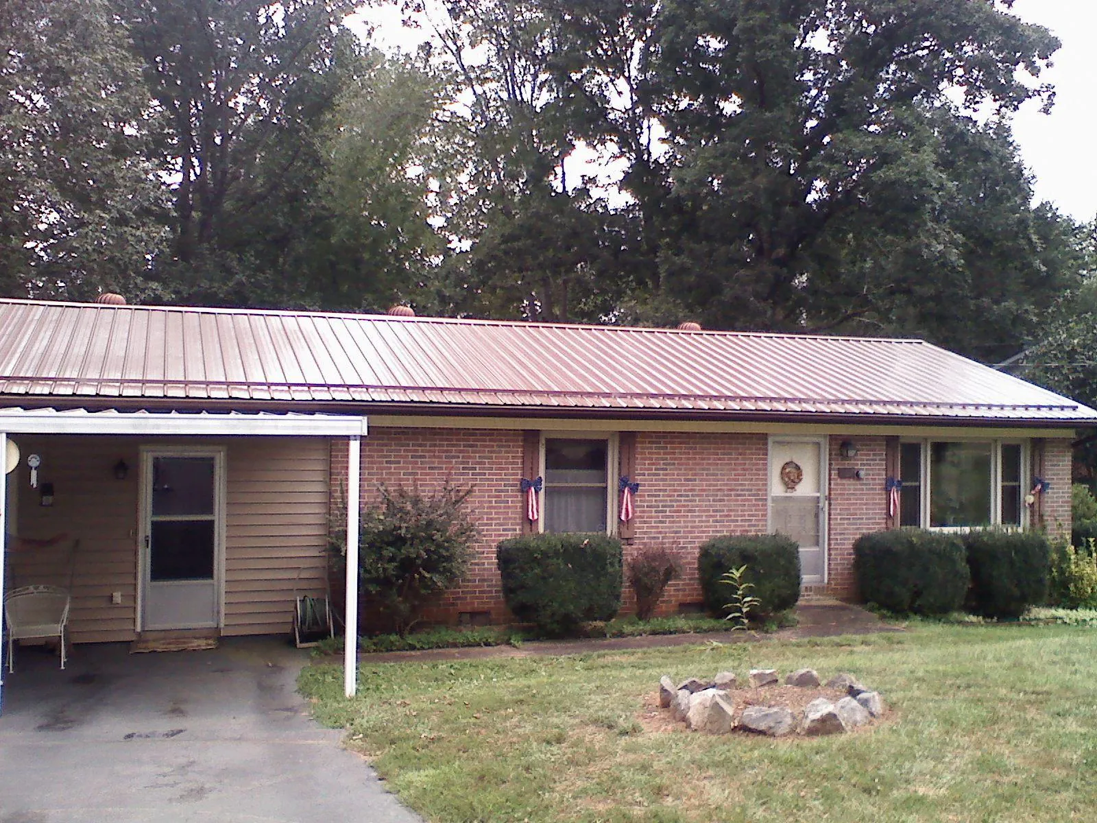 Bronze metal roof and carport on a brick ranch home — Roof Repair work by our crew in Irwin